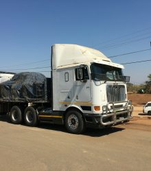 a semi truck with a trailer is parked on the side of the road